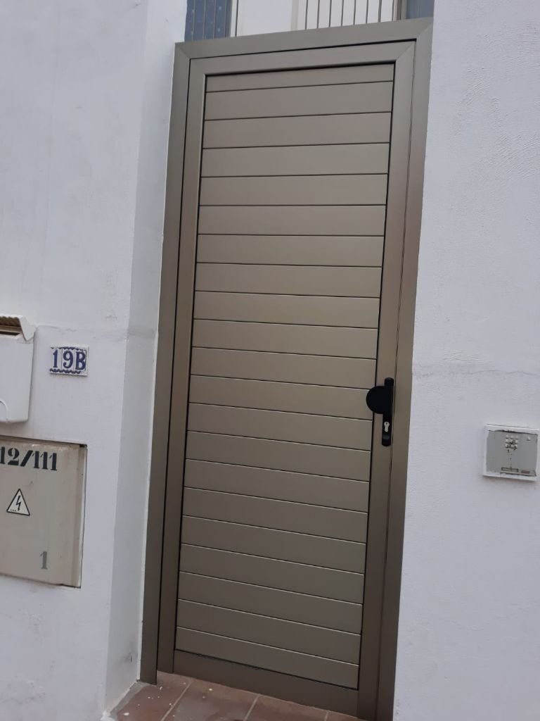 Trabajo realizado - puerta de aluminio en acabado marrón